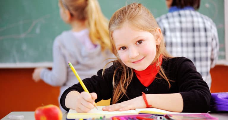 Girl writing in school classroom